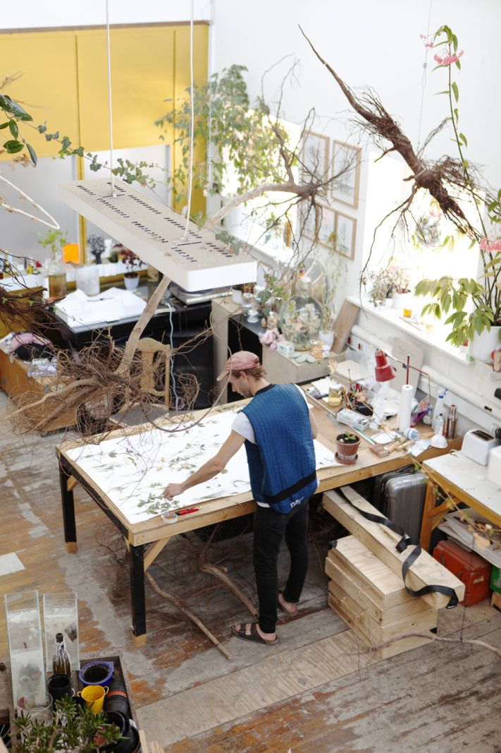 Kom med i Rune Bosses værksted</br>Rune Bosse går rundt i det højloftede rum og arbejder dedikeret og møjsommeligt med de mange planter, som han henter i naturen udenfor og bearbejder i sit kunstlaboratorium.</br>Foto: Erika Svensson
