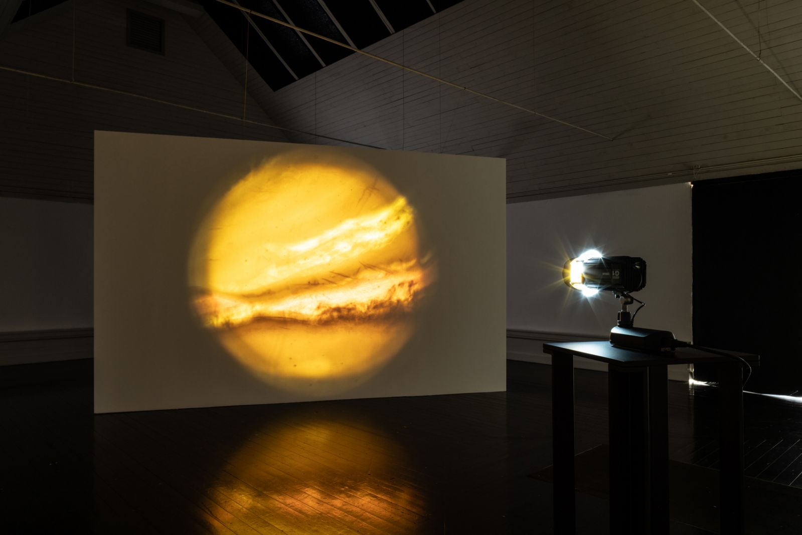 Kosmisk eksistens på Den Frie Udstillingsbygning</br>Marie Kølbæk Iversen - Slide. Værket består af et dias skåret af en sort opal, som gennemlyses af en gobo-projektor. Projektionen ligner et stilbillede men er i virkeligheden i konstant bevægelse.  </br>Foto: PR-Foto / Den Frie Udstillingsbygning - David Stjernholm