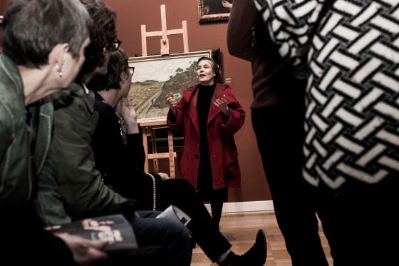 Krop om ord om billeder</br>En rødklædt Marianne Høgsbro foran Lauritz Hartz' Landskab med lyngbakker.</br>Foto: Morten Germund