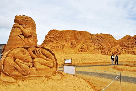 GIGANTISKE DINOSAUERE I SØNDERVIGS SANDBANKER</br>Sandskulpturfestivalen består af både enkeltskulpturer og en 200 m x 7 m sandvæg, der indkapsler festivalpladsen, og beskytter mod vind og vejr.</br>Foto: Fine Spind – Sophie Stride Geyti